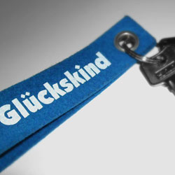 Ein blauer Schlüsselanhänger mit der Aufschrift Glückskind